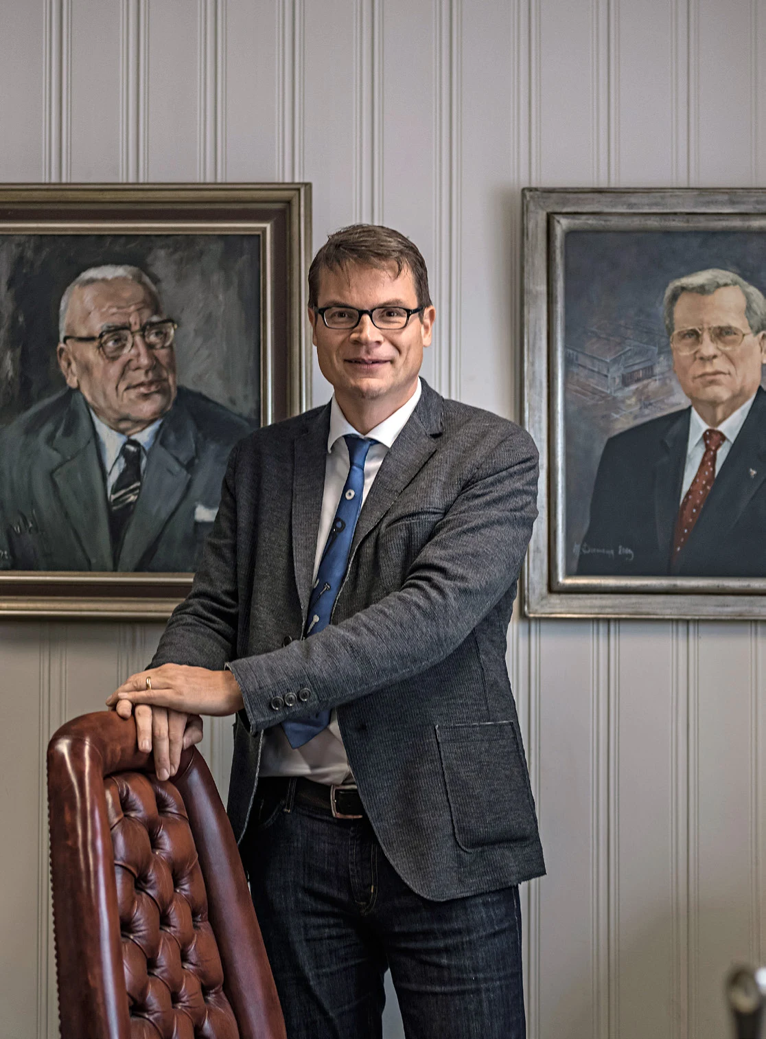 Meinolf Gockel steht vor den Porträts seines Großvaters und seines Vaters